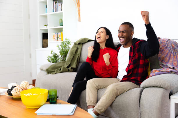istock Friends enjoy watching TV, cheering. 1390480634