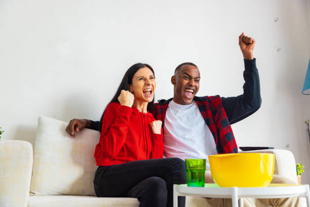 istock Friends enjoy watching TV, cheering. 1390480677