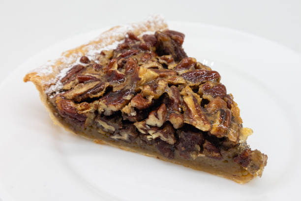 istock Slice of an American Style Pecan Pie on a White Plate 1390480998