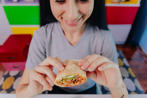 istock Woman enjoying her lovely chicken burrito. 1390481881