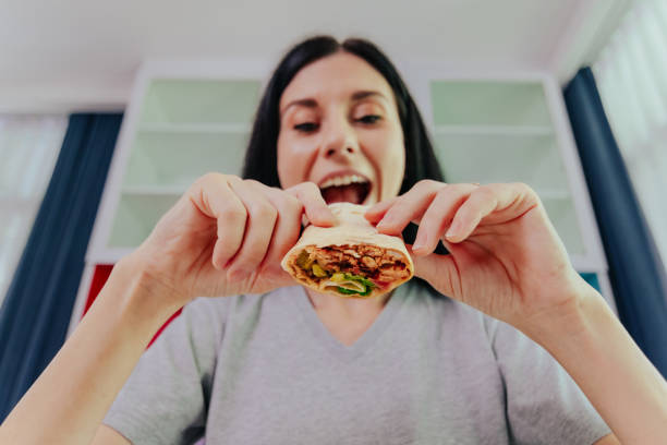 istock Woman enjoying her lovely chicken burrito. 1390481897