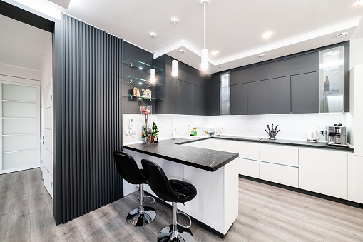 Large, modern studio kitchen with high chairs and furniture