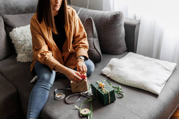 istock Happy woman gets ready for Christmas and wrapping a gift 1390487186