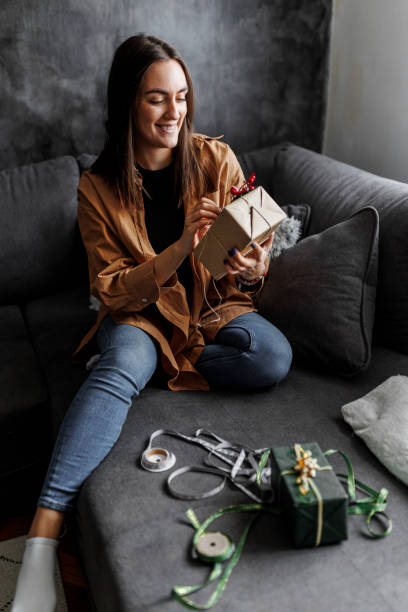 istock Happy woman gets ready for Christmas and wrapping a gift 1390487204