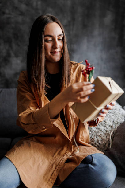istock Happy woman gets ready for Christmas and wrapping a gift 1390487244