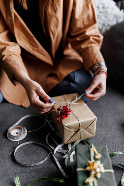 istock Happy woman gets ready for Christmas and wrapping a gift 1390487312