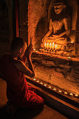 istock Novice buddhist monks contemplating inside temple, Myanmar 1390487488