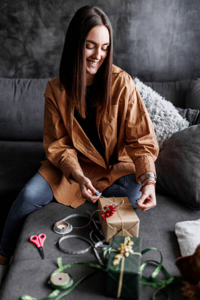 istock Happy woman gets ready for Christmas and wrapping a gift 1390487489