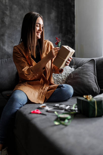 istock Happy woman gets ready for Christmas and wrapping a gift 1390487607