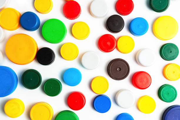 Colored plastic caps from bottles of water isolated on a white background. Close-up, top view. Recycling used plastic - a solution to the problem of plastic contamination.