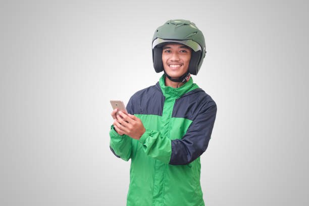 Asian online taxi rider holding a mobile phone stock photo