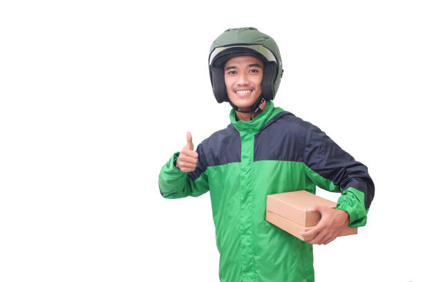 Asian online courier rider delivering package and box while showing thumb up hand gesture Portrait of Asian online courier rider wearing green jacket and helmet delivering package and box and showing thumb up hand gesture. Isolated image on white background vietnamese man taxi motorbike driver stock pictures, royalty-free photos & images