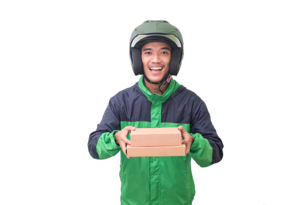 Asian online courier rider delivering package and box for customer Portrait of Asian online courier driver wearing green jacket and helmet delivering package and box for customer. Isolated image on white background vietnamese man taxi motorbike driver stock pictures, royalty-free photos & images