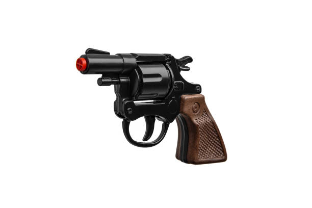 おもちゃの銃のリボルバー。茶色のハンドルが付いた黒いピストル。白い背景に分離する - toy gun ストックフォトと画像