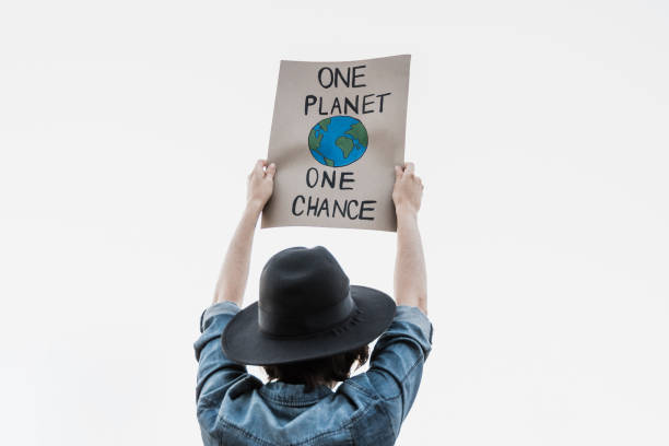 istock Young activist marching and protest for climate change holding banner - Demonstration for Ecology and environment concept 1390496343