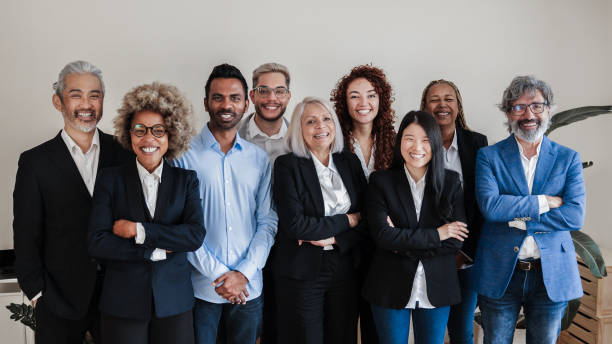 multi-ethnic generational modern office: successful business team smiling on camera - focus on asian girl face - adult senior adult black white imagens e fotografias de stock