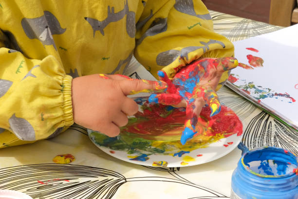 istock Early childhood development activity: finger painting outside on a sunny day 1390496641
