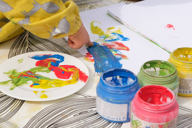 istock Early childhood development activity: finger painting outside on a sunny day 1390496643