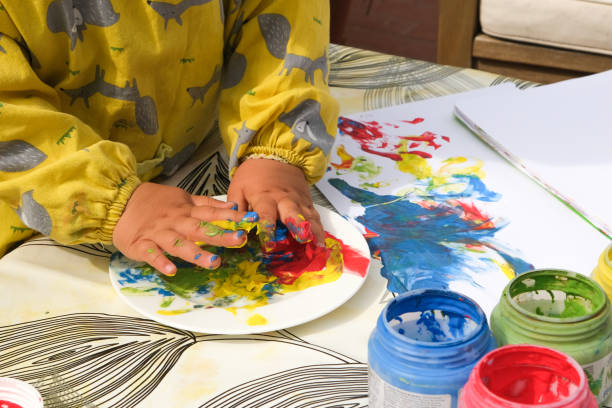 istock Early childhood development activity: finger painting outside on a sunny day 1390496668