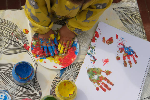 istock Early childhood development activity: finger painting outside on a sunny day 1390496674