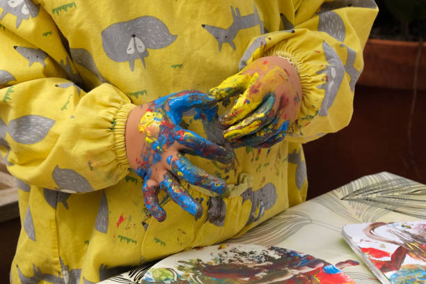 istock Early childhood development activity: finger painting outside on a sunny day 1390496688