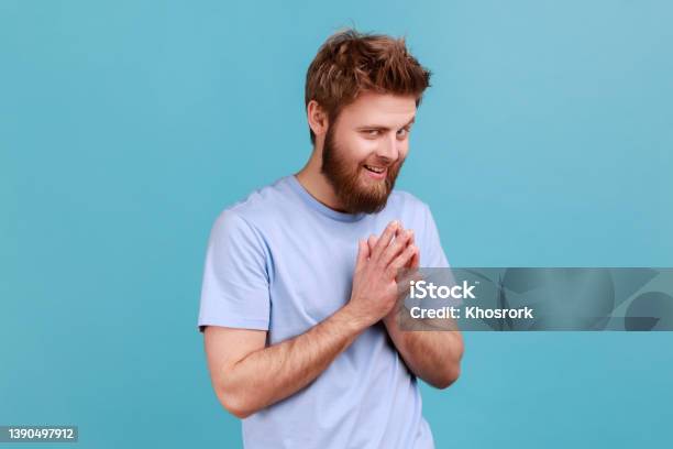 Man In Tshirt Schemes Something Keeps Hands Together Makes Plans Sly Expression Looks Thoughtfully Stock Photo - Download Image Now