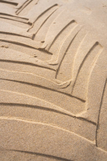 nadruki opon ciągnika osadzone w piaszczystej plaży z geometrycznym wzorem - tire track making tire construction zdjęcia i obrazy z banku zdjęć