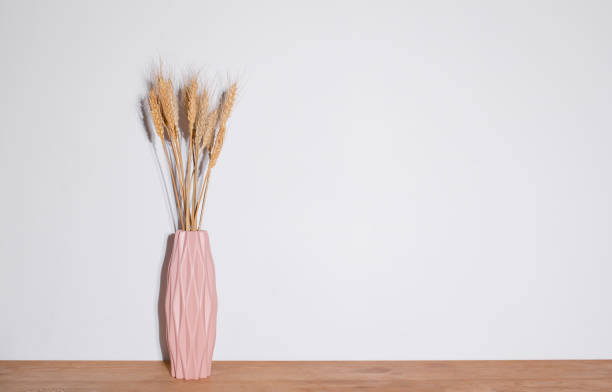 istock Ears of wheat in a rose vase on a light background. 1390502964