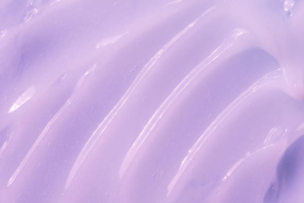 istock Slime textured background. Moisturizing beauty creme, balm swatch, paint. Lilac cream, moisturizer, shampoo spread, cosmetic smear background. Creamy fluid skincare lotion mousse 1390504045