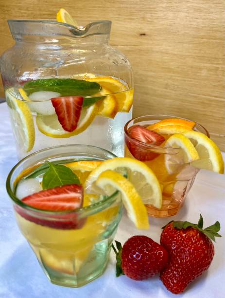 istock strawberry and lemon infused water in pitcher,  glasses and  strawberries on white tablecloth 1390506830
