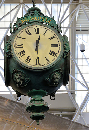 Milwaukee, Wisconsin, USA: General Mitchell International Airport - looking up at a hanging vintage cast iron clock - space frame truss in the background - MKE central mall - 12:29.