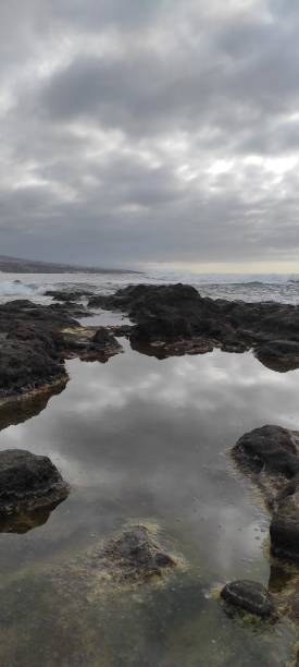 istock Pond by the rough sea on a cloudy day 1390509018