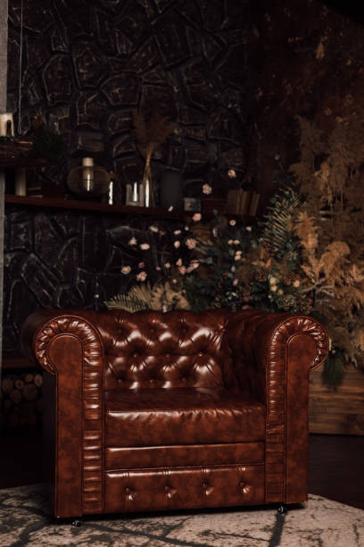 istock Brown leather armchair against a dark brick wall 1390510336