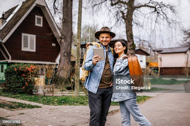 Portrait Of Young Couple Using Digital Tablet While Exploring New Travel Destination Stock Photo - Download Image Now