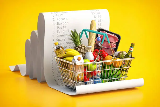 Photo of Shopping basket with foods on receipt. Grocery  expenses budget, inflation and consumerism concept.