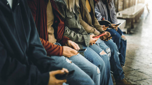 istock Millenial people watching smart mobile phones outside - Teens using modern technology - Young people addicted to cellphone 1390518425