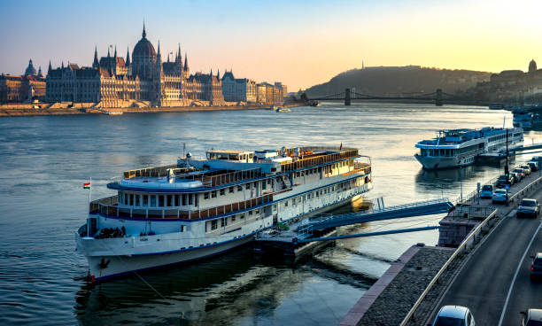 vue grand angle du parlement hongrois à budapest vue de l’autre côté du danube avec des bateaux de croisière au premier plan - budapest danube river cruise hungary photos et images de collection