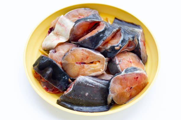 istock Catfish cut pieces in yellow plate on white background. 1390521863