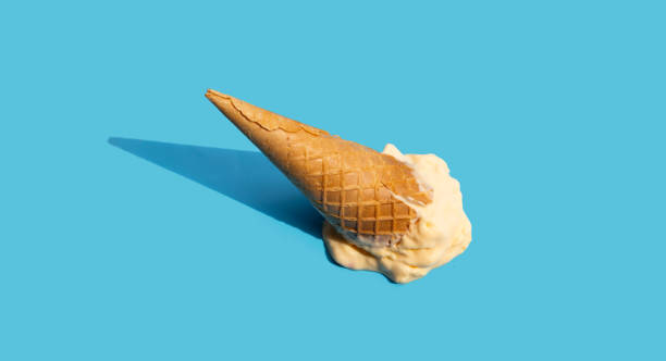 istock Melting ice cream balls with waffle cone on blue background. 1390521992
