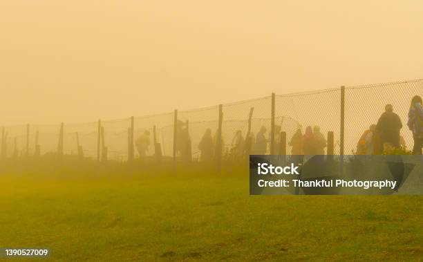 Refugees Walk To The Border Behind The Wire In A Cold Day Under Fog Stock Photo - Download Image Now
