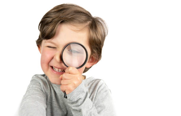 istock Boy with magnifying glass in hand on white background. Search concept 1390527958