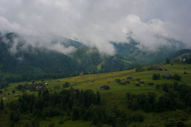 nebel und regen in den karpaten. bergdorf dzembronya in den karpaten, ukraine. panoramafoto der mystischen berglandschaft. - eastern europe mountain range mountain village stock-fotos und bilder