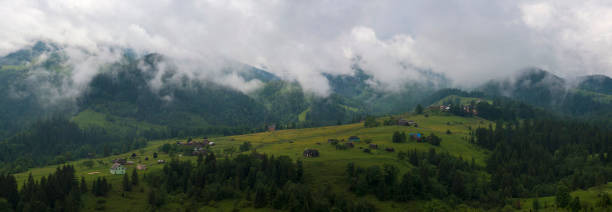 nebel und regen in den karpaten. bergdorf dzembronya in den karpaten, ukraine. panoramafoto der mystischen berglandschaft. - eastern europe mountain range mountain village stock-fotos und bilder