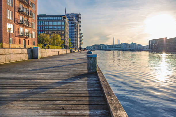 해질녘에 운하와 주거용 건물의 물 근처의 나무 제방. 코펜하겐, 덴마크 - embankment 뉴스 사진 이미지