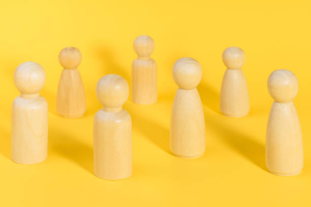 istock Wooden people figures stand on yellow backdrop, relationship, communication problems between people. 1390530873