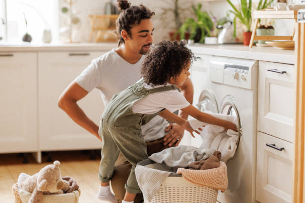 istock Son helping dad to load washing machine 1390531725
