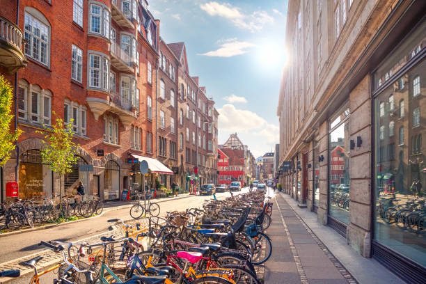 muchas bicicletas estacionadas en una estrecha y antigua calle minter møntergade en el casco antiguo de copenhague, dinamarca - sidewalk cafe built structure cafe day fotografías e imágenes de stock