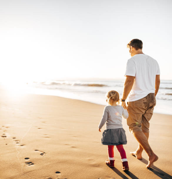 dad and daughter walking on the beach dad and daughter walking on the beach childrens day photos stock pictures, royalty-free photos & images