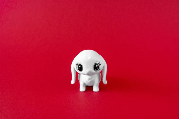istock White puppy toy on red background. Minimalist concept, front view 1390539744