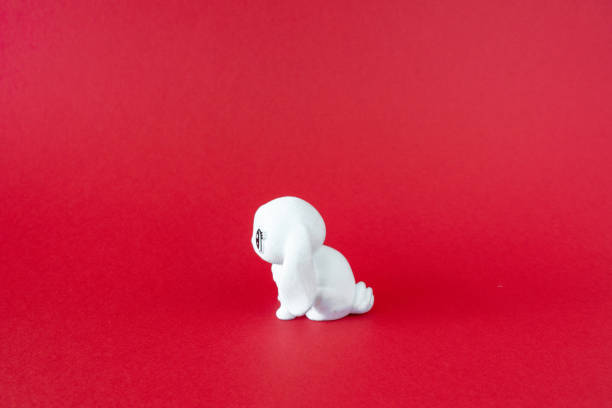 istock White puppy toy on red background. Minimalist concept, front view 1390540633